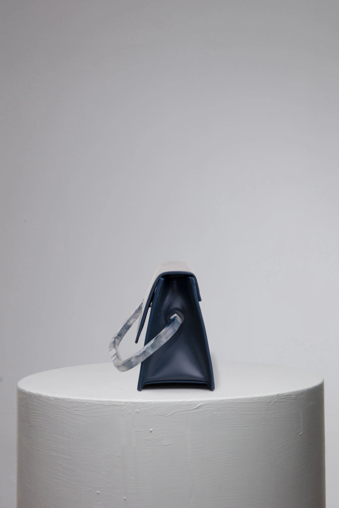 Navy geunine leather handbag on grey stand