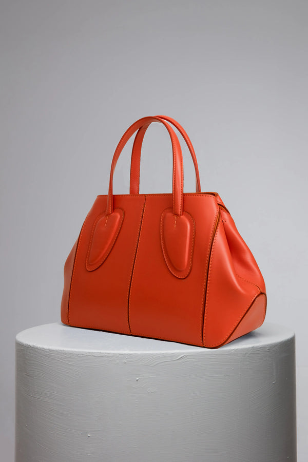 medium orange calf leather woman handbag on grey stand