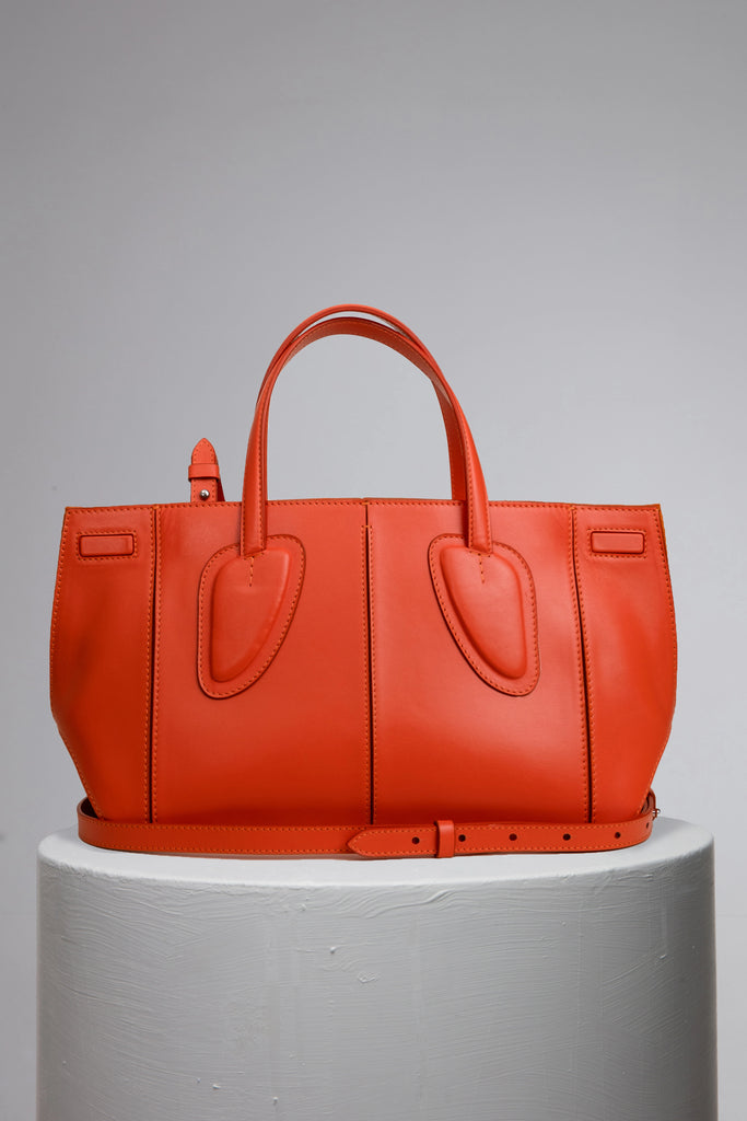 medium orange calf leather woman handbag on grey stand