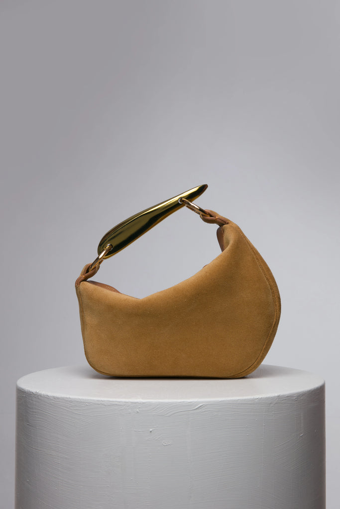 Brown suede leather soft handbag with metal handle on a white stand