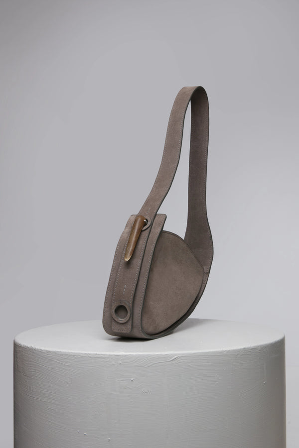 Grey oval shape suede leather handbag with metal accessories