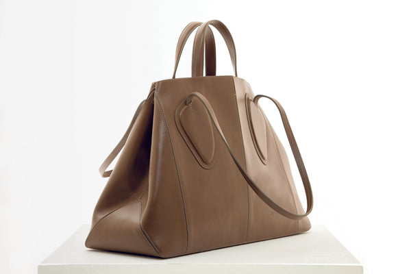 Calf leather maxi non-structured rectangle tote bag with non-removable two leather handle and two leather shoulder strap on a white stand