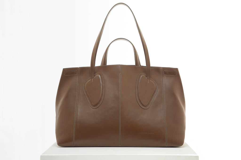 Calf leather maxi non-structured rectangle tote bag with non-removable two leather handle and two leather shoulder strap on a white stand