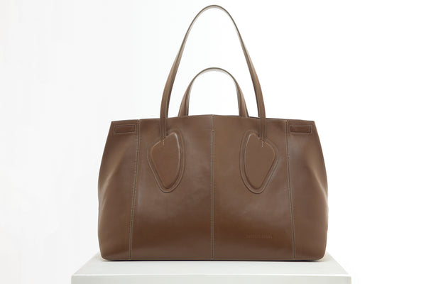 Calf leather maxi non-structured rectangle tote bag with non-removable two leather handle and two leather shoulder strap on a white stand