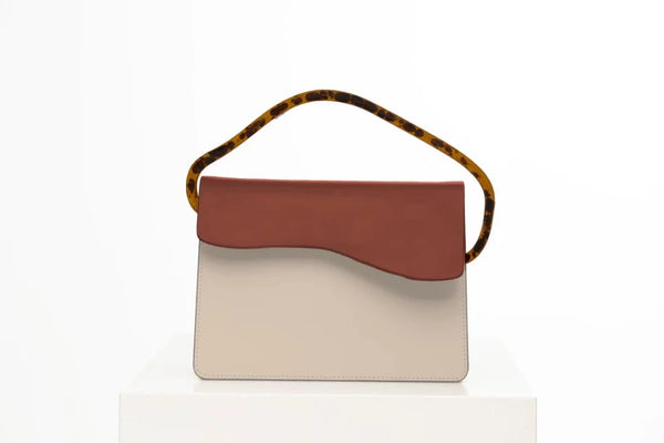 Rectangular women's handbag with a beige genuine leather body and a brown flap, bio resin handle and long shoulder handle, on a white stand.