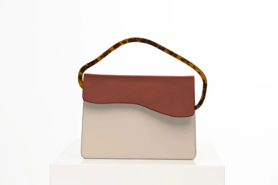Rectangular women's handbag with a beige genuine leather body and a brown flap, bio resin handle and long shoulder handle, on a white stand.