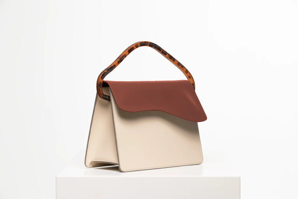 Rectangular women's handbag with a beige genuine leather body and a brown flap, bio resin handle and long shoulder handle, on a white stand.