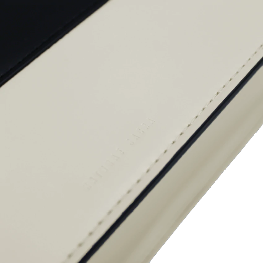 Beige black calf leather medium structured rectangle bag with bio resin handle and removable calf leather shoulder strap on a white stand