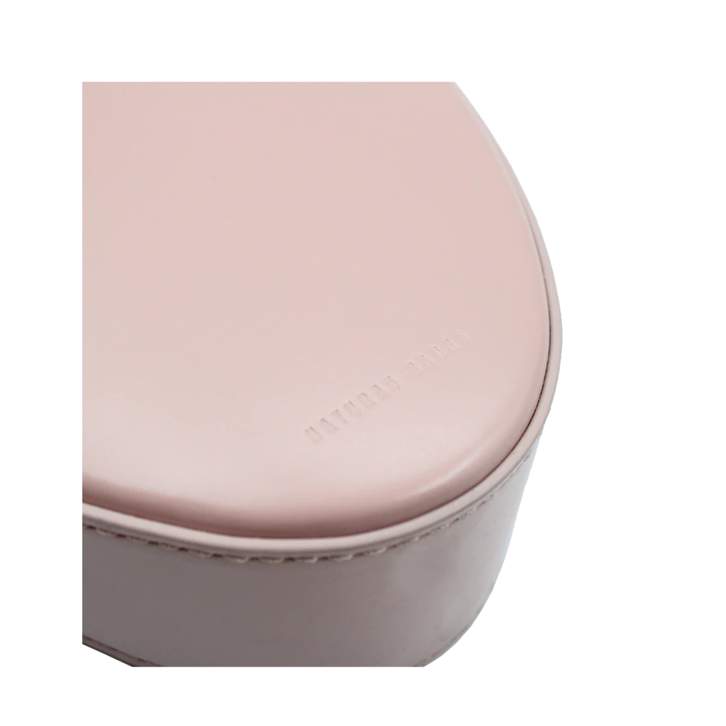 Flap topped oval structured dusty rose calf leather cross body bag with an adjustable leather and natural resin chain linked strap on a white stand