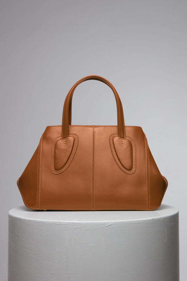 brown leather handbag on white stand