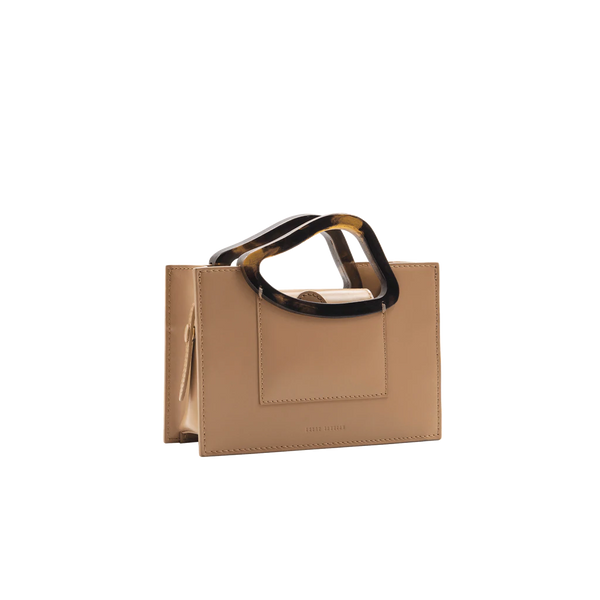 Rectangle shaped champagne calf leather saddle bag with natural resin handle holder and remowable calf leather handle strap on a white stand
