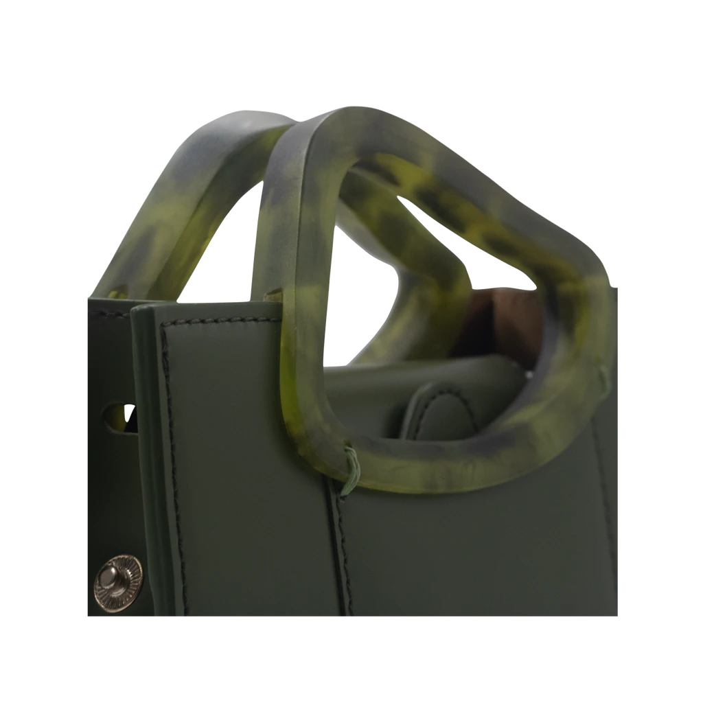 Rectangle shaped olive calf leather saddle bag with natural resin handle holder and remowable calf leather handle strap on a white stand