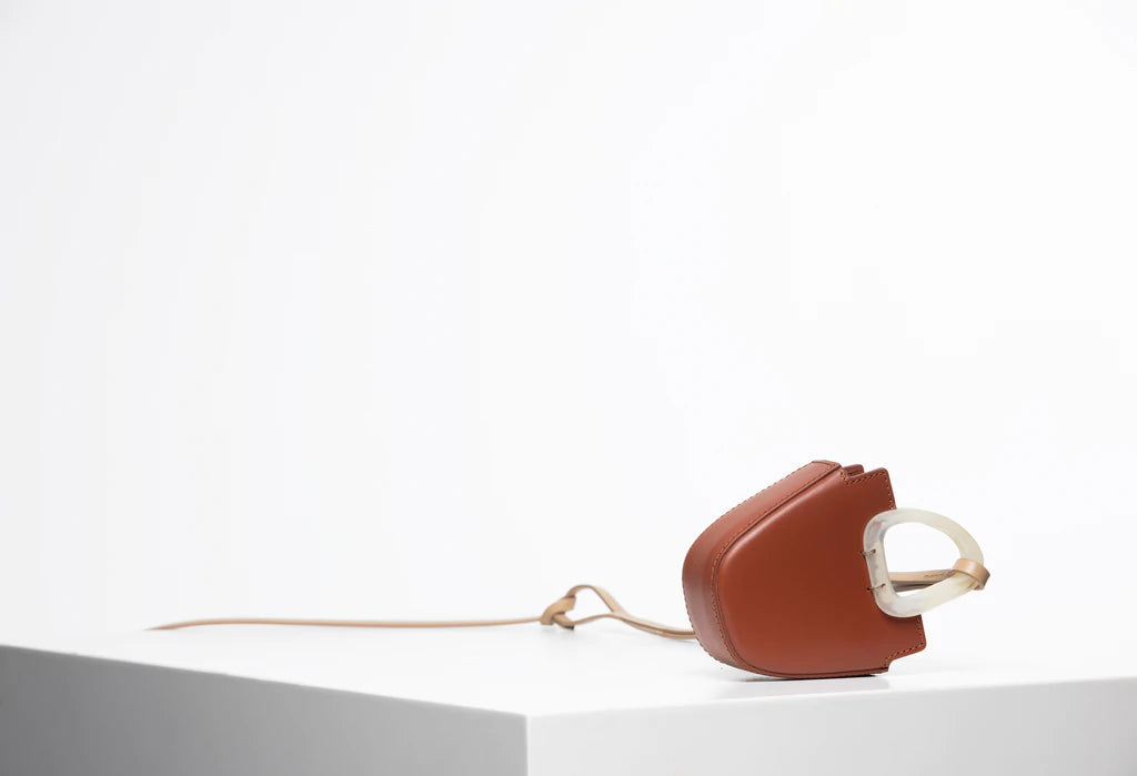 Mini flat topped oval structured retro brown calf leather tote bag with natural resin round handles and a removable adjustable calf leather strap.